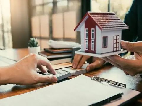 مجسم منزل أثناء إجراء معاملة مالية مرتبطة بشراء عقار
